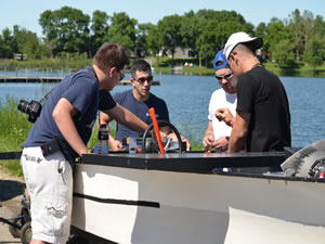 Students making last minute adjustments to their boat